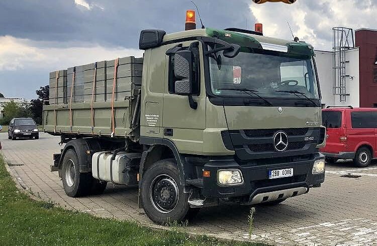 Zelený nákladní vůz Mercedes-Benz Actros s valníkovou nástavbou
