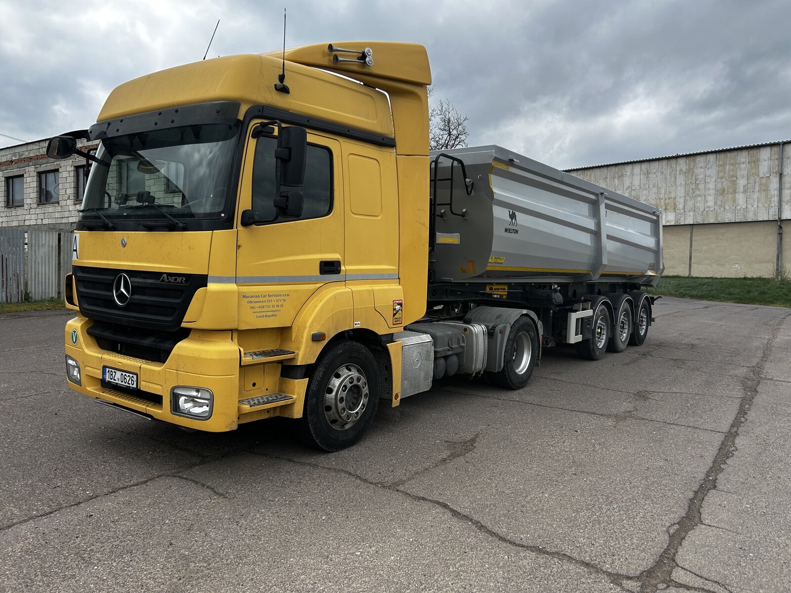 Žlutý tahač Mercedes-Benz Axor se sklápěcím návěsem