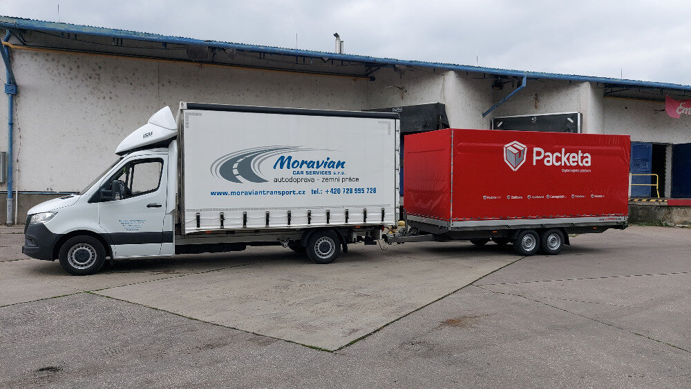 Dodávka Moravian car services s firemním polepem a přívěsem